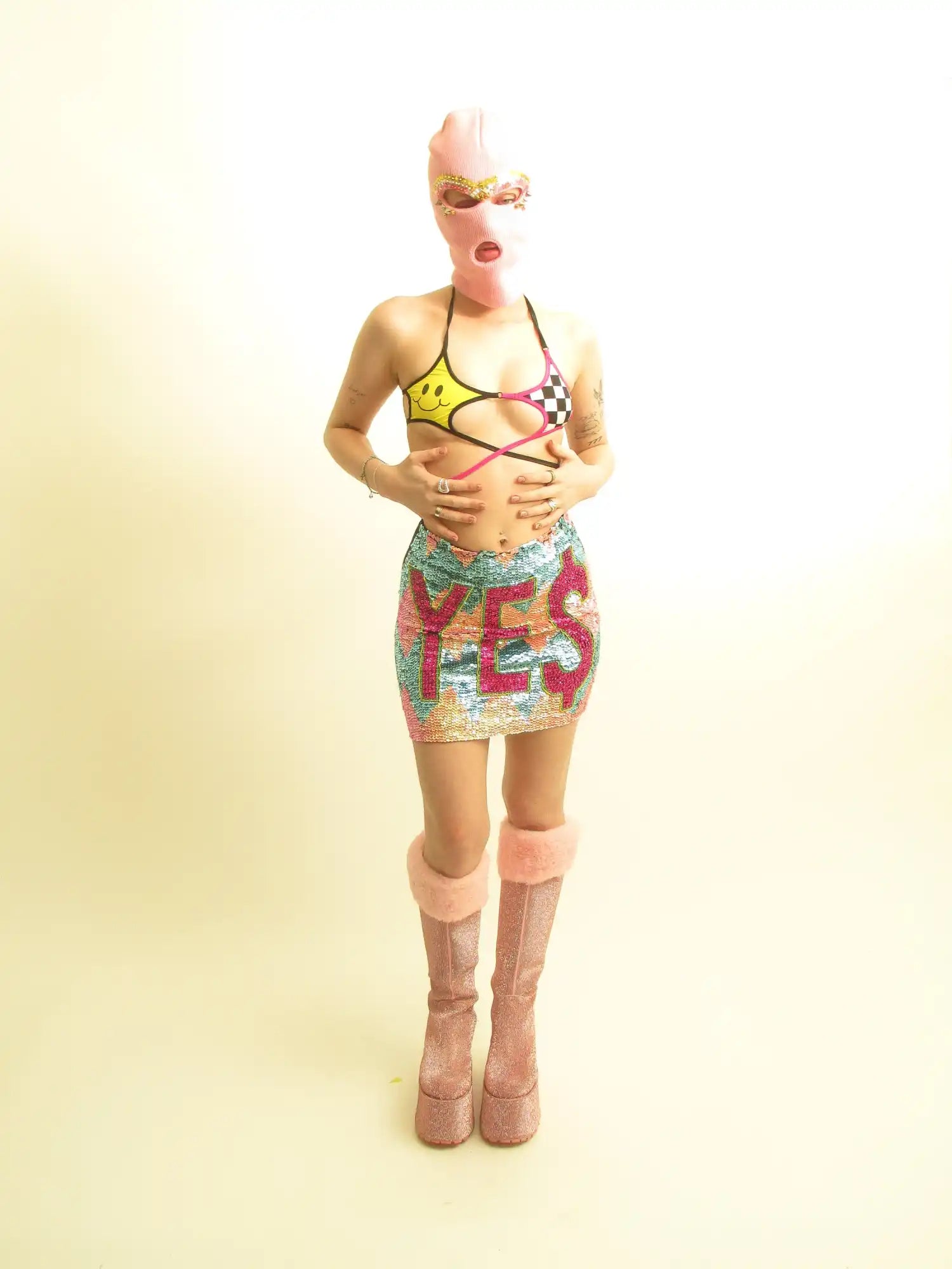 A figure wearing a colorful patterned outfit with platform boots and a blonde hairstyle.